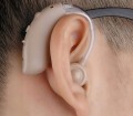 Mini aparat słuchowy BTE beżowy z akumulatorem, redukcją szumów i ładowaniem USB. W zestawie: 4 zatyczki, kabel, ładowarka, etui, instrukcja. Lekki i dyskretny, idealny dla seniorów.